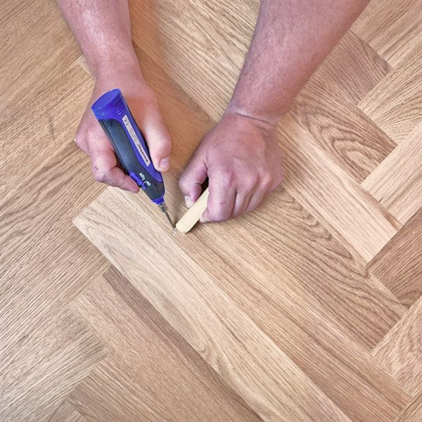Restored oak parquet floor with a seamless filled repair that flexes with the boards