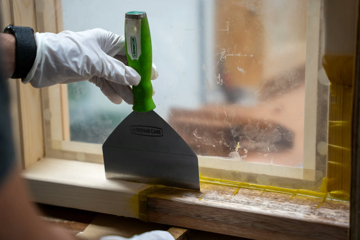 Repair Care filling knife held against a window sill during a repair