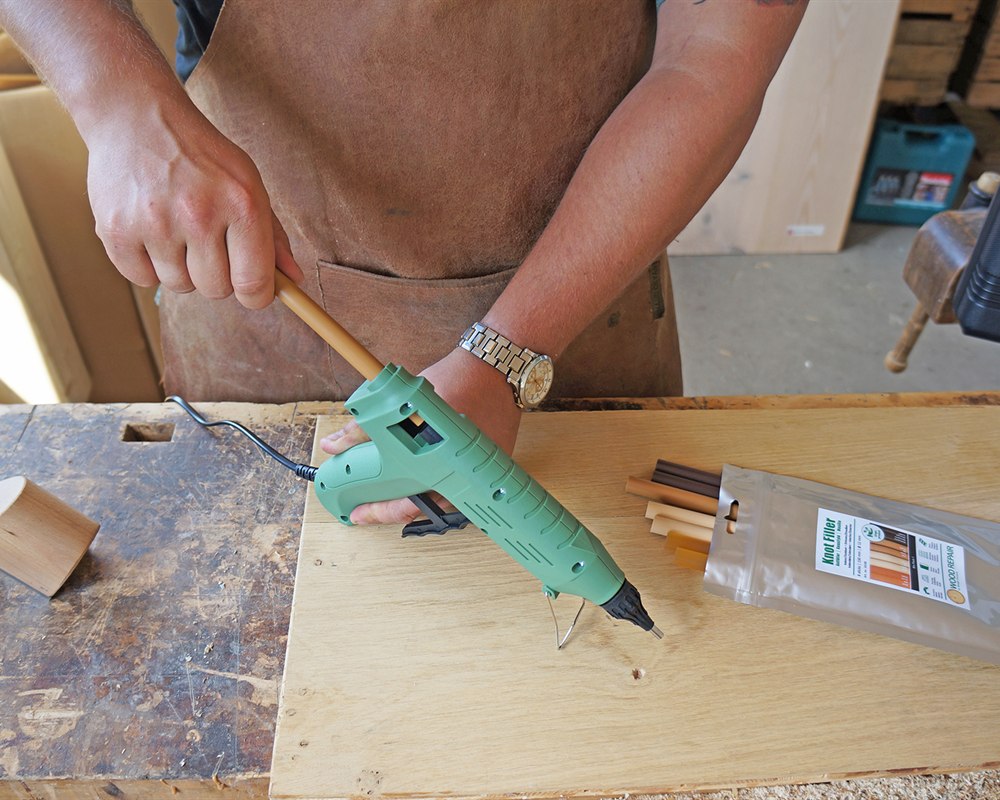 The full Wood Repair system on the bench: gun, color-matched filler sticks and the mix bag