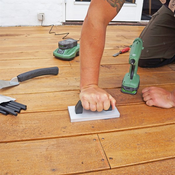 Repaired wooden terrace decking outdoors, the filled spots holding up to weather and sun